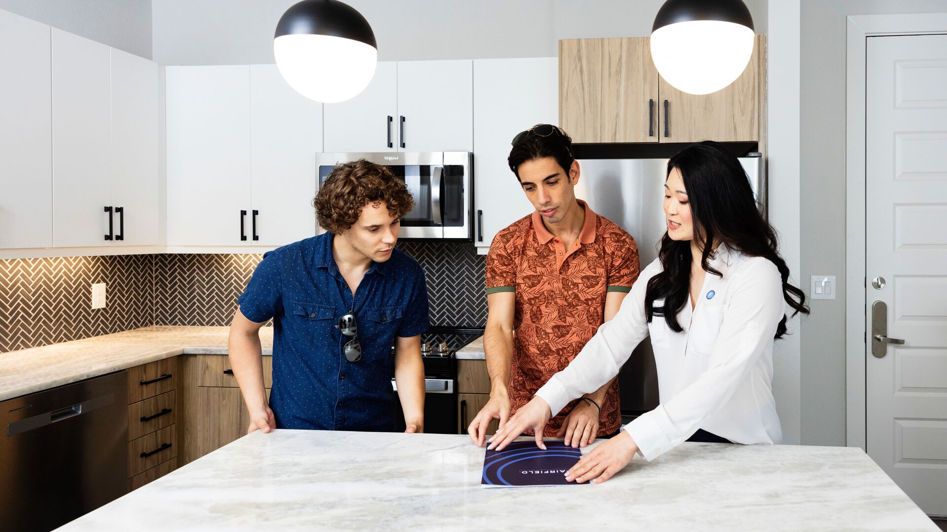 Leasing agent with two prospective residents touring an apartment